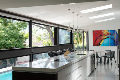 シドニーにあるコンテンポラリースタイルのおしゃれなアイランドキッチン (アンダーカウンターシンク、フラットパネル扉のキャビネット、白いキャビネット) の写真