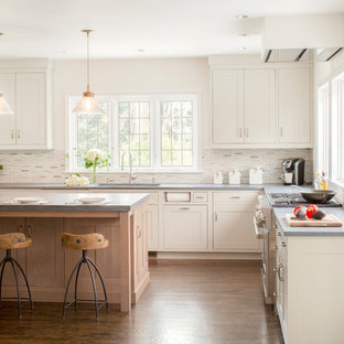 Inspiration for a large transitional l-shaped eat-in kitchen in New York with an integrated sink, shaker cabinets, grey cabinets, limestone benchtops, beige splashback, mosaic tile splashback, stainless steel appliances, dark hardwood floors and with island.