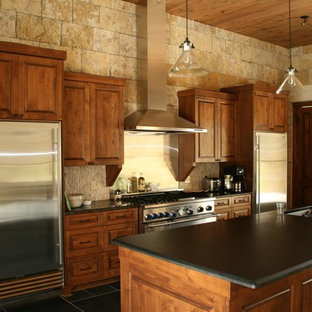 Mid-sized farmhouse eat-in kitchen inspiration - Eat-in kitchen - mid-sized cottage single-wall porcelain tile and black floor eat-in kitchen idea in Austin with an undermount sink, shaker cabinets, medium tone wood cabinets, solid surface countertops, beige backsplash, stone slab backsplash, stainless steel appliances and an island