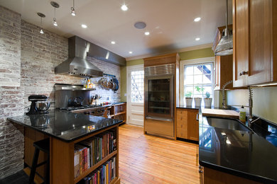 Large mountain style u-shaped medium tone wood floor and brown floor eat-in kitchen photo in Boston with a peninsula, an undermount sink, shaker cabinets, medium tone wood cabinets, granite countertops, brown backsplash, brick backsplash and stainless steel appliances