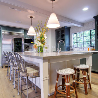 Large traditional kitchen designs - Example of a large classic l-shaped light wood floor kitchen design in Los Angeles with mosaic tile backsplash, stainless steel appliances, green cabinets, an island, recessed-panel cabinets and granite countertops