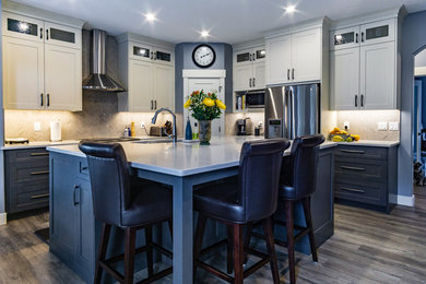 Kitchen - transitional vinyl floor and gray floor kitchen idea in Calgary with shaker cabinets, quartz countertops, gray backsplash, stainless steel appliances, an island and white countertops