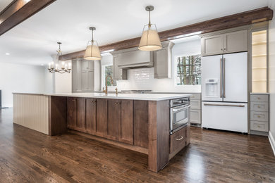 Imagen de cocina clásica renovada con armarios estilo shaker, puertas de armario grises, encimera de cuarzo compacto, salpicadero blanco, suelo de madera en tonos medios, una isla, suelo marrón y encimeras blancas