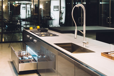 Example of a mid-sized trendy single-wall concrete floor eat-in kitchen design in Los Angeles with an integrated sink, open cabinets, dark wood cabinets, stainless steel countertops, stainless steel appliances and an island