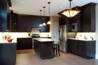 Küche in U-Form mit Schrankfronten im Shaker-Stil, braunen Schränken, Granit-Arbeitsplatte und Kücheninsel in Ottawa