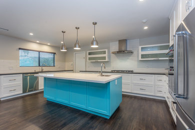 Example of a large trendy u-shaped dark wood floor open concept kitchen design in Los Angeles with a single-bowl sink, shaker cabinets, white cabinets, quartzite countertops, white backsplash, subway tile backsplash, stainless steel appliances and an island