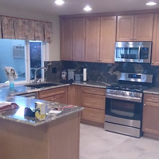 Design ideas for a mid-sized contemporary u-shaped eat-in kitchen in Orange County with an undermount sink, shaker cabinets, light wood cabinets, granite benchtops, black splashback, stone slab splashback, stainless steel appliances, porcelain floors, no island, beige floor and black benchtop.