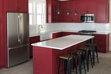 Inspiration for a kitchen remodel in Other with a single-bowl sink, shaker cabinets, red cabinets, quartz countertops, porcelain backsplash, stainless steel appliances and white countertops