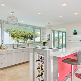 Mid-sized contemporary open concept kitchen ideas - Example of a mid-sized trendy l-shaped travertine floor and beige floor open concept kitchen design in San Diego with an undermount sink, flat-panel cabinets, gray cabinets, a peninsula, stainless steel appliances, multicolored backsplash, mosaic tile backsplash, solid surface countertops and white countertops