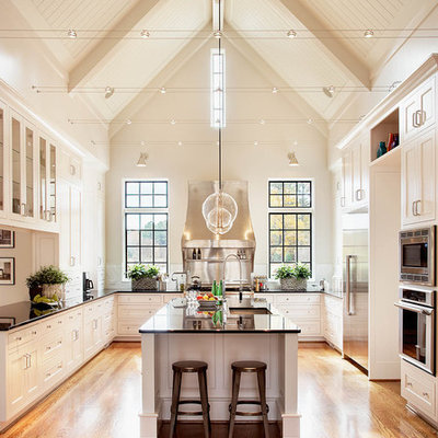 Huge elegant u-shaped medium tone wood floor kitchen photo in Raleigh with shaker cabinets, white cabinets, stainless steel appliances, an undermount sink, granite countertops, an island and black countertops