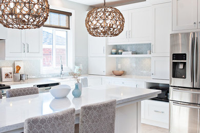 Transitional l-shaped beige floor kitchen photo in Toronto with shaker cabinets, white cabinets, gray backsplash, stainless steel appliances, an island and gray countertops