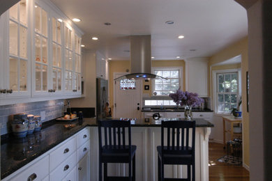 Example of a mid-sized cottage light wood floor and brown floor kitchen design in San Francisco with a single-bowl sink, shaker cabinets, white cabinets, granite countertops, blue backsplash, ceramic backsplash, stainless steel appliances and an island