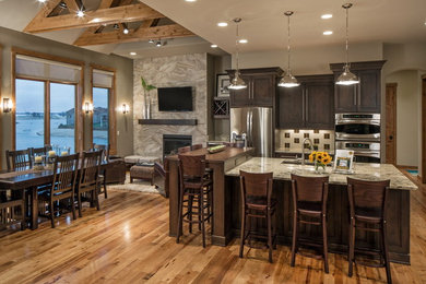 Inspiration for a traditional galley kitchen in Omaha with a submerged sink, recessed-panel cabinets, dark wood cabinets and stainless steel appliances.