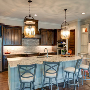 Photo of a mid-sized transitional l-shaped kitchen in Indianapolis with a drop-in sink, shaker cabinets, brown cabinets, granite benchtops, grey splashback, cement tile splashback, stainless steel appliances, vinyl floors, with island, brown floor and grey benchtop.