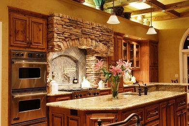 Example of a mountain style eat-in kitchen design in St Louis with an undermount sink, raised-panel cabinets, medium tone wood cabinets, granite countertops and stainless steel appliances