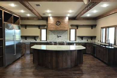 Inspiration for a large rustic u-shaped dark wood floor eat-in kitchen remodel in New Orleans with an island, recessed-panel cabinets, dark wood cabinets, an undermount sink, terrazzo countertops, multicolored backsplash, stone slab backsplash and stainless steel appliances