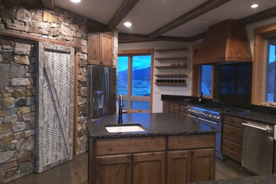 Enclosed kitchen - mid-sized farmhouse l-shaped dark wood floor and beige floor enclosed kitchen idea in Denver with an undermount sink, flat-panel cabinets, distressed cabinets, granite countertops, black backsplash, stainless steel appliances and an island