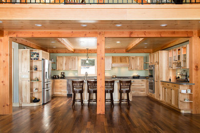 Example of a large mountain style u-shaped dark wood floor eat-in kitchen design in Burlington with an undermount sink, shaker cabinets, medium tone wood cabinets, solid surface countertops, stainless steel appliances and an island