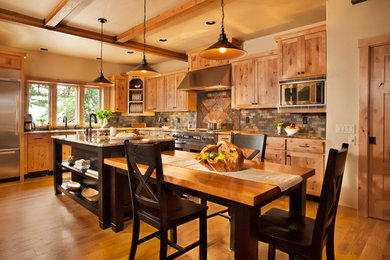 Example of a large mountain style l-shaped light wood floor and brown floor eat-in kitchen design in Portland with an undermount sink, shaker cabinets, brown cabinets, granite countertops, brown backsplash, subway tile backsplash, stainless steel appliances, an island and brown countertops