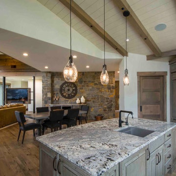 Rustic Island with Granite Top with Curved Side Opens to Dining Room