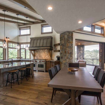 Rustic Kitchen Opens to Dining Room with Stone Columns