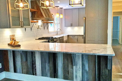 Inspiration for a mid-sized rustic u-shaped light wood floor open concept kitchen remodel in Atlanta with a farmhouse sink, shaker cabinets, gray cabinets, quartzite countertops, white backsplash, subway tile backsplash, stainless steel appliances and a peninsula