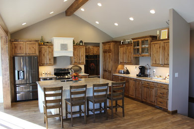 Large mountain style l-shaped medium tone wood floor and brown floor open concept kitchen photo in Other with an undermount sink, raised-panel cabinets, medium tone wood cabinets, granite countertops, stainless steel appliances and an island