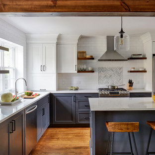 Transitional kitchen designs - Inspiration for a transitional l-shaped medium tone wood floor kitchen remodel in Chicago with an undermount sink, shaker cabinets, blue cabinets, white backsplash, subway tile backsplash, stainless steel appliances, an island and white countertops