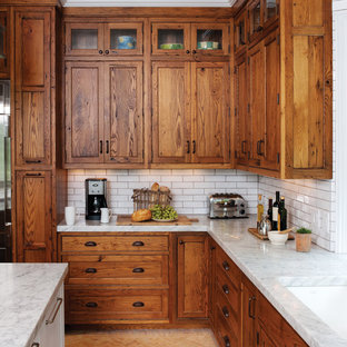 Ejemplo de cocina en L, rústica, con fregadero bajoencimera, armarios con paneles empotrados, puertas de armario de madera oscura, encimera de granito, salpicadero blanco, salpicadero de azulejos tipo metro y suelo de ladrillo