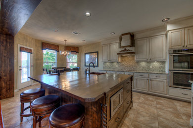 Eat-in kitchen - mid-sized rustic l-shaped eat-in kitchen idea in Austin with a single-bowl sink, wood countertops, stainless steel appliances and an island