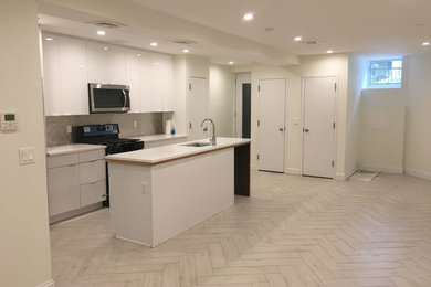 Mid-sized minimalist galley porcelain tile and beige floor eat-in kitchen photo in New York with an undermount sink, flat-panel cabinets, white cabinets, solid surface countertops, metallic backsplash, metal backsplash, stainless steel appliances and an island