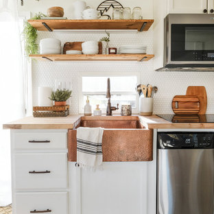 Idee per una piccola cucina parallela country con lavello stile country, ante con bugna sagomata, ante bianche, top in legno, paraspruzzi bianco, paraspruzzi in gres porcellanato, elettrodomestici in acciaio inossidabile, pavimento in laminato, nessuna isola e pavimento grigio