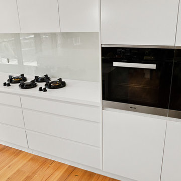 White kitchen with glass splashback