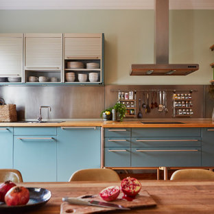 Einzeilige Stilmix Wohnküche ohne Insel mit Einbauwaschbecken, flächenbündigen Schrankfronten, blauen Schränken, Arbeitsplatte aus Holz, Küchenrückwand in Metallic, Rückwand aus Metallfliesen und brauner Arbeitsplatte in London