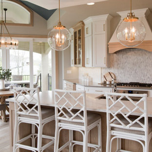 Large french country open concept kitchen ideas - Example of a large french country galley light wood floor and brown floor open concept kitchen design in Kansas City with a farmhouse sink, recessed-panel cabinets, white cabinets, marble countertops, multicolored backsplash, ceramic backsplash, stainless steel appliances, an island and white countertops