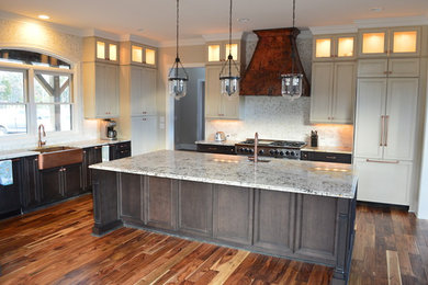 Example of a large classic l-shaped dark wood floor kitchen design in Raleigh with a farmhouse sink, shaker cabinets, white cabinets, white backsplash, stainless steel appliances and an island