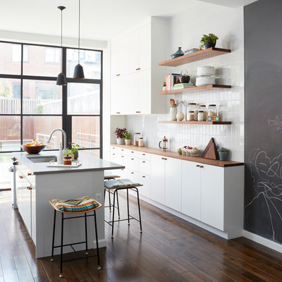 Kitchen - contemporary galley dark wood floor and brown floor kitchen idea in New York with an undermount sink, flat-panel cabinets, white cabinets, wood countertops, white backsplash, an island and brown countertops