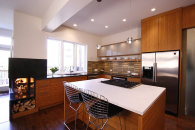 Inspiration for a mid-sized modern u-shaped medium tone wood floor eat-in kitchen remodel in Chicago with an undermount sink, flat-panel cabinets, medium tone wood cabinets, concrete countertops, multicolored backsplash, ceramic backsplash, stainless steel appliances and an island