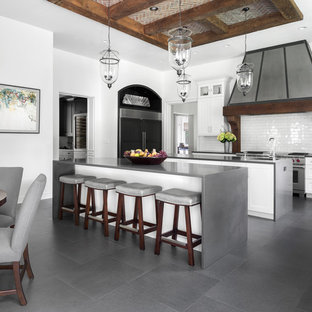 Expansive transitional galley eat-in kitchen in New York with recessed-panel cabinets, white cabinets, white splashback, subway tile splashback, stainless steel appliances, porcelain floors, multiple islands, grey floor and grey benchtop.