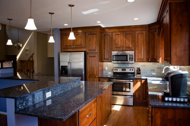 Example of a mid-sized transitional l-shaped eat-in kitchen design in Denver with recessed-panel cabinets, medium tone wood cabinets, granite countertops, multicolored backsplash, mosaic tile backsplash, stainless steel appliances, an island and blue countertops