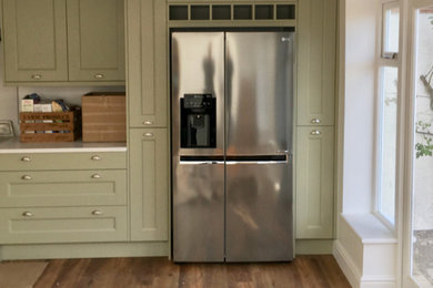This is an example of a contemporary kitchen in Buckinghamshire with grey cabinets, white splashback, no island, brown floors and white worktops.