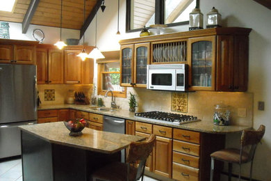 ミネアポリスにある中くらいなコンテンポラリースタイルのおしゃれなキッチン (ダブルシンク、レイズドパネル扉のキャビネット、中間色木目調キャビネット、白いキッチンパネル、セラミックタイルのキッチンパネル、シルバーの調理設備、セラミックタイルの床) の写真