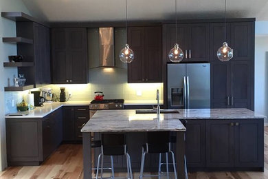 Example of a mid-sized transitional l-shaped light wood floor and beige floor open concept kitchen design in Salt Lake City with an undermount sink, shaker cabinets, dark wood cabinets, marble countertops, gray backsplash, glass sheet backsplash, stainless steel appliances, an island and gray countertops