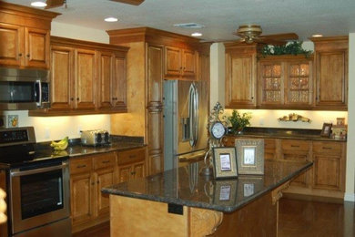 Example of a mid-sized classic l-shaped ceramic tile enclosed kitchen design in Phoenix with flat-panel cabinets, light wood cabinets, onyx countertops and an island