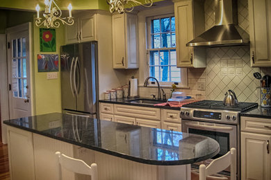 Foto på ett mellanstort vintage linjärt kök, med en undermonterad diskho, luckor med upphöjd panel, vita skåp, granitbänkskiva, vitt stänkskydd, stänkskydd i porslinskakel, rostfria vitvaror, mellanmörkt trägolv och en köksö