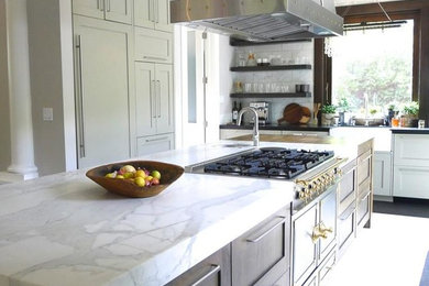 Foto di un cucina con isola centrale classico con ante bianche, top in marmo, paraspruzzi bianco, elettrodomestici in acciaio inossidabile, pavimento con piastrelle in ceramica e pavimento bianco