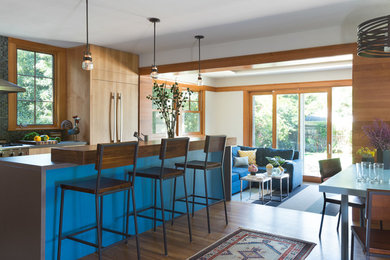 Mid-sized arts and crafts l-shaped medium tone wood floor open concept kitchen photo in San Francisco with a single-bowl sink, flat-panel cabinets, medium tone wood cabinets, concrete countertops, blue backsplash, ceramic backsplash, stainless steel appliances and an island