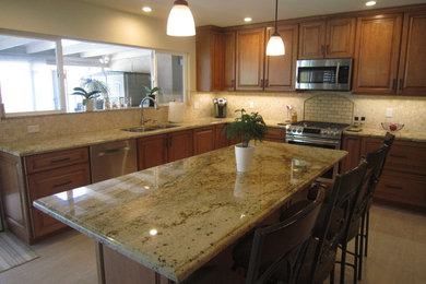 Large elegant u-shaped porcelain tile and beige floor eat-in kitchen photo in San Diego with a double-bowl sink, raised-panel cabinets, medium tone wood cabinets, granite countertops, beige backsplash, stone tile backsplash, stainless steel appliances and an island
