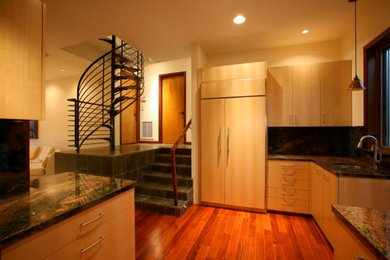 Ejemplo de cocina actual con armarios con paneles lisos y puertas de armario de madera oscura