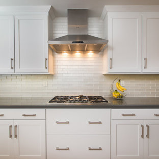 This is an example of a mid-sized modern u-shaped eat-in kitchen in San Diego with a drop-in sink, recessed-panel cabinets, white cabinets, grey splashback, ceramic splashback, stainless steel appliances, terra-cotta floors and a peninsula.